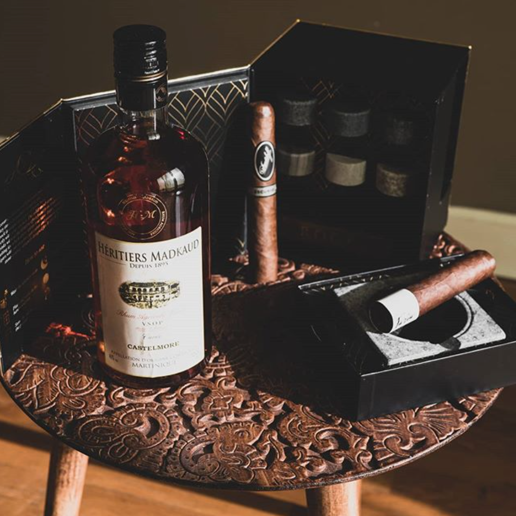 Bottle of liquor and cigars on a decorative wooden tray