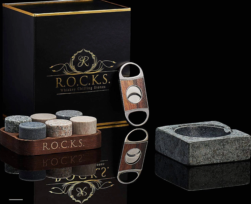 R.O.C.K.S. whiskey charring stones set with a cutter and branded box on a reflective surface.