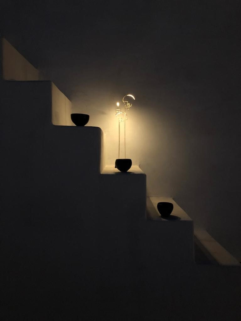 Staircase with a lamp and two black bowls in a dimly lit room