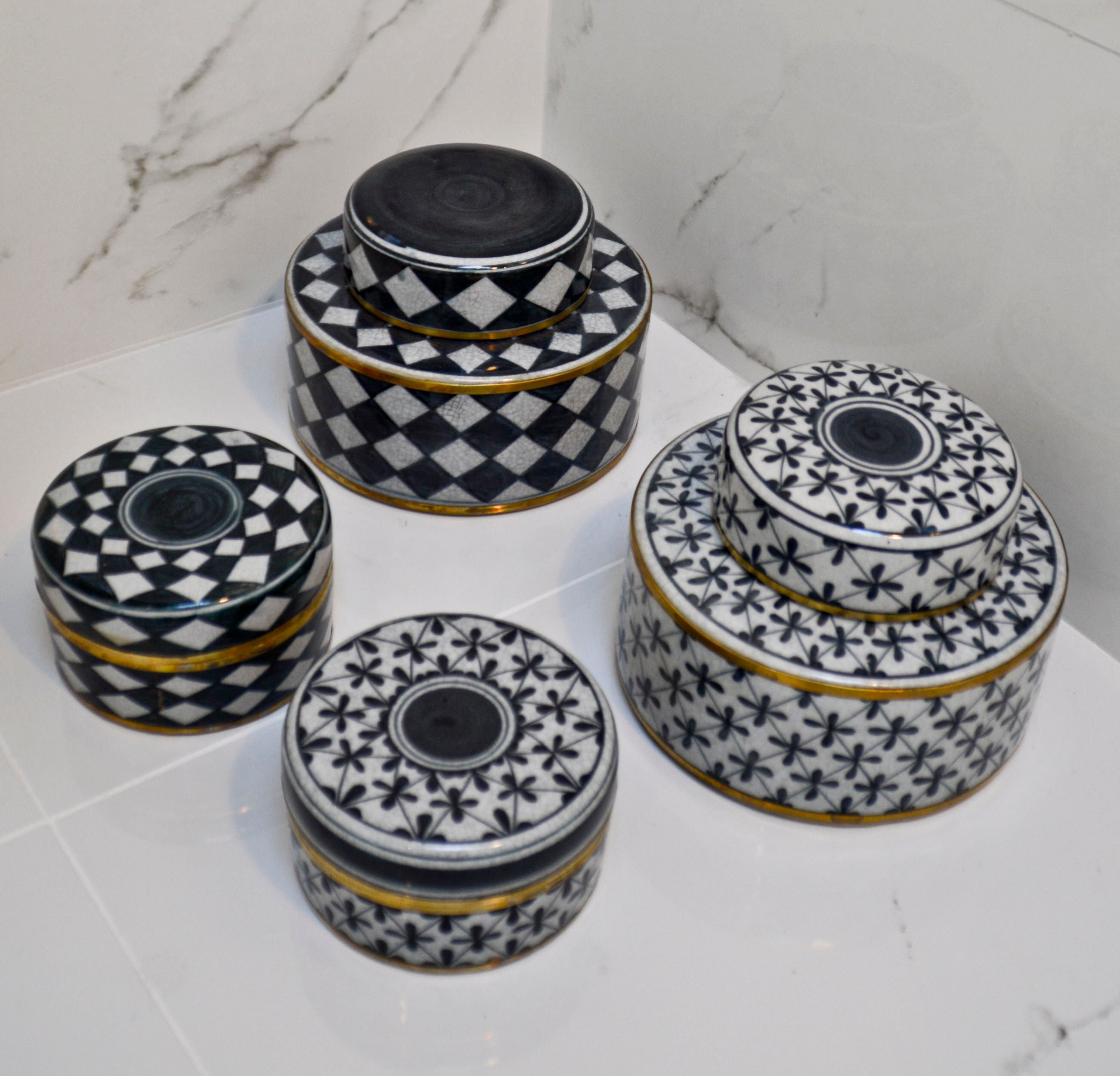 Set of black and white patterned ceramic jars on a marble surface