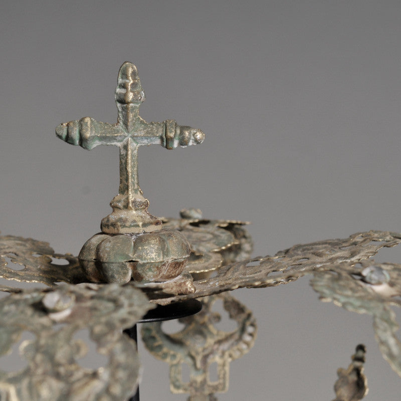 Bronze close up of metal crown with cross on a gray background