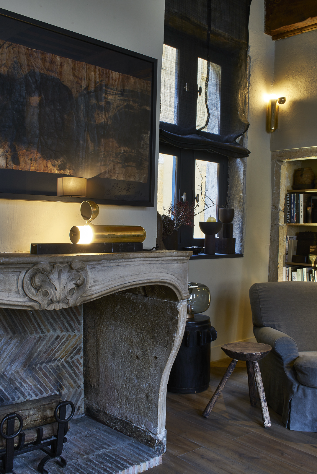 Living room with a fireplace, armchair, and large window.