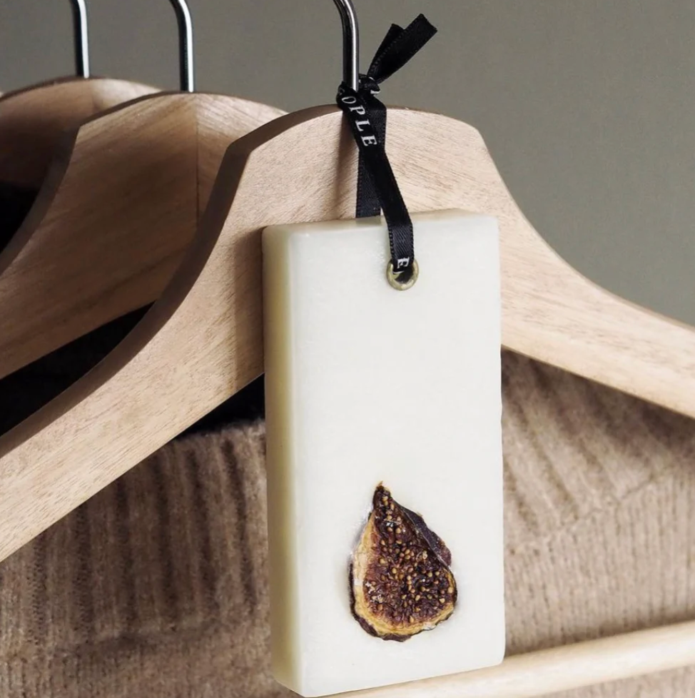 Rectangular wax bar with a fig slice on a wooden hanger
