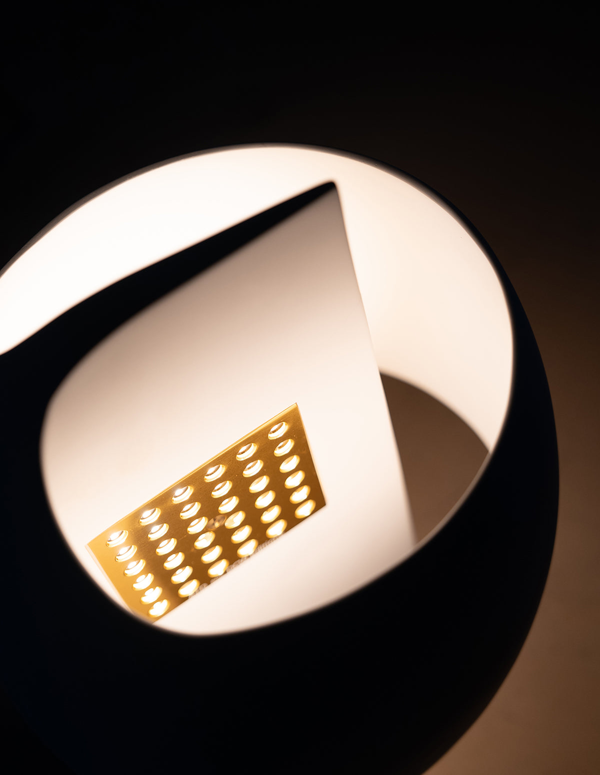 Close-up of a LED light bulb with a metallic base on a black background