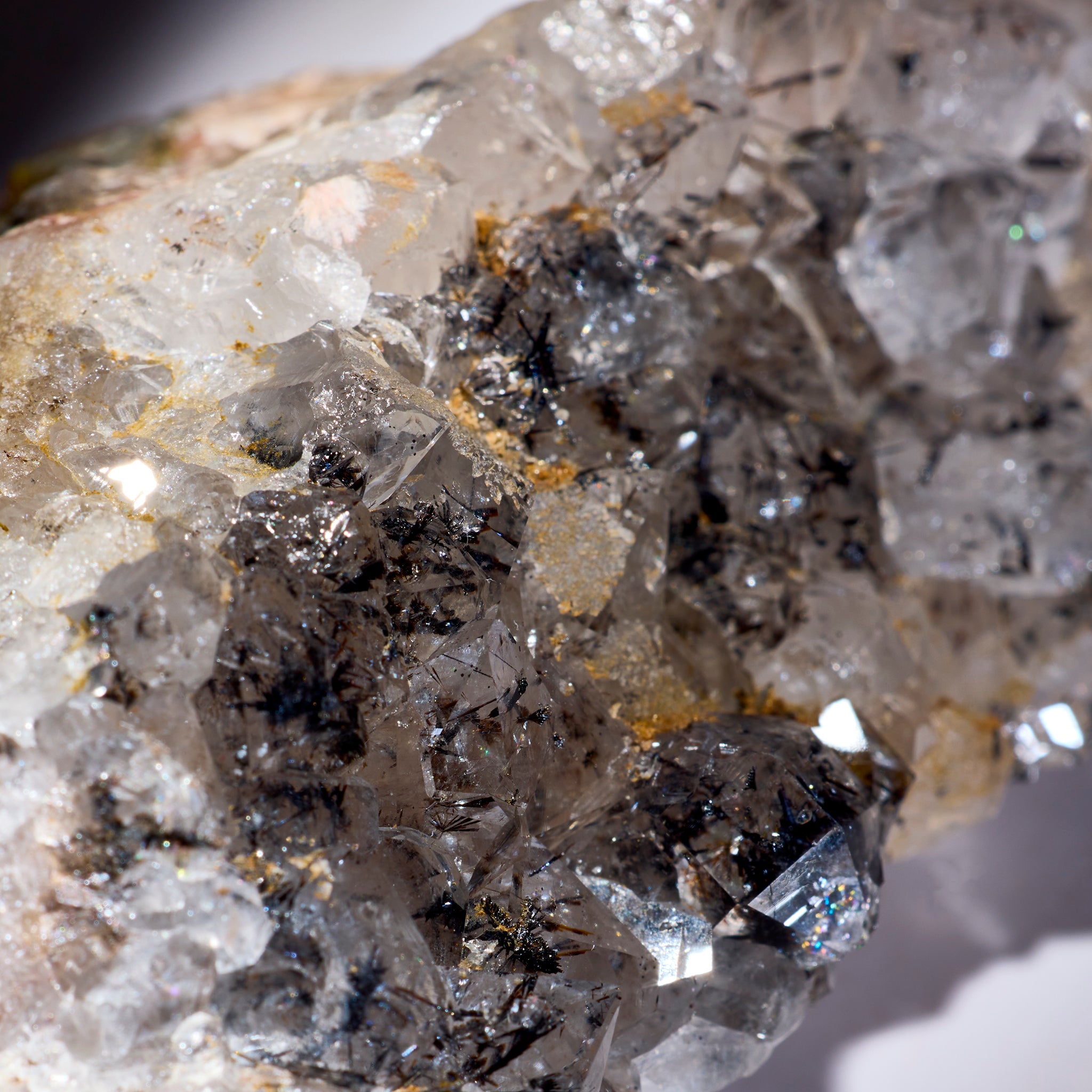 Close-up of a crystal formation with clear and grayish crystals on a light background