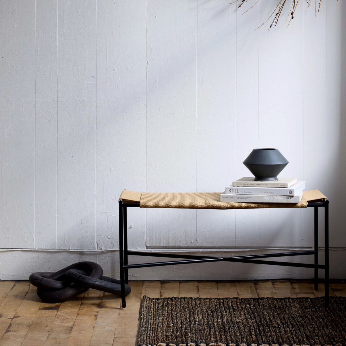 Console table with a vase and books against a white wall