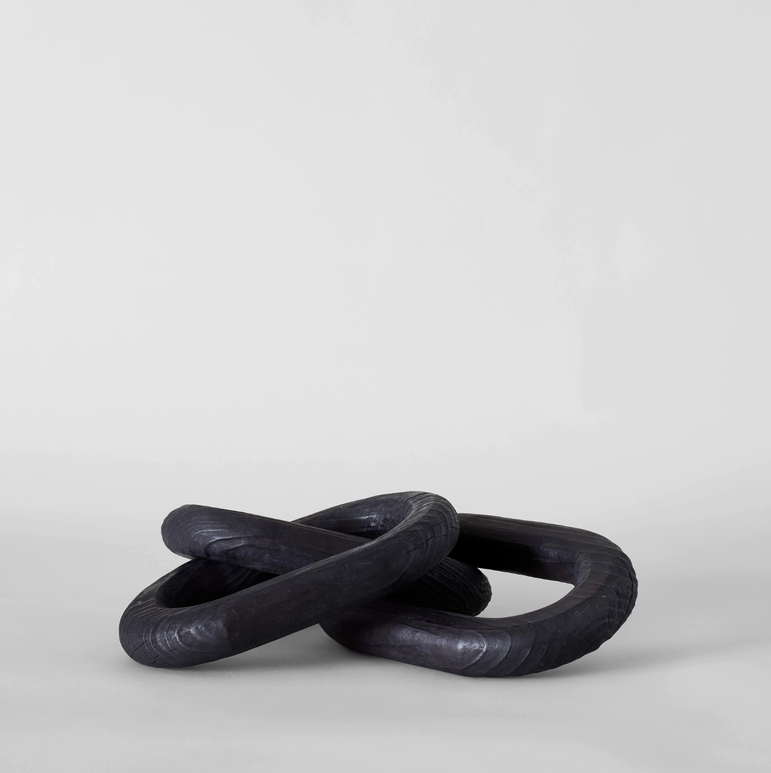 Two black rings intertwined on a light gray background