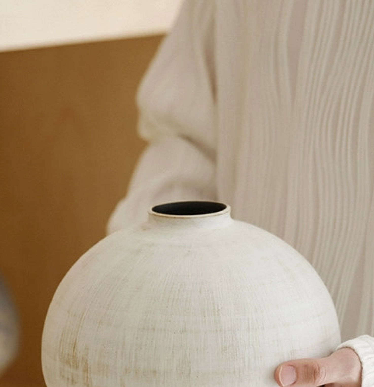 white vase held in hands 