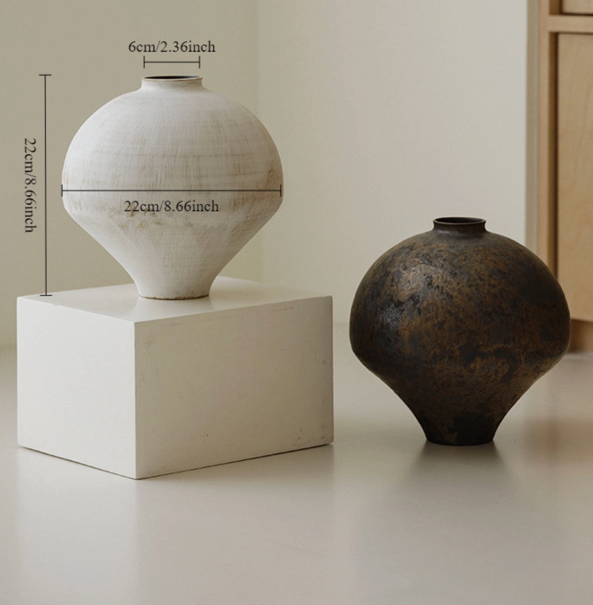 white and brown vase on white floor