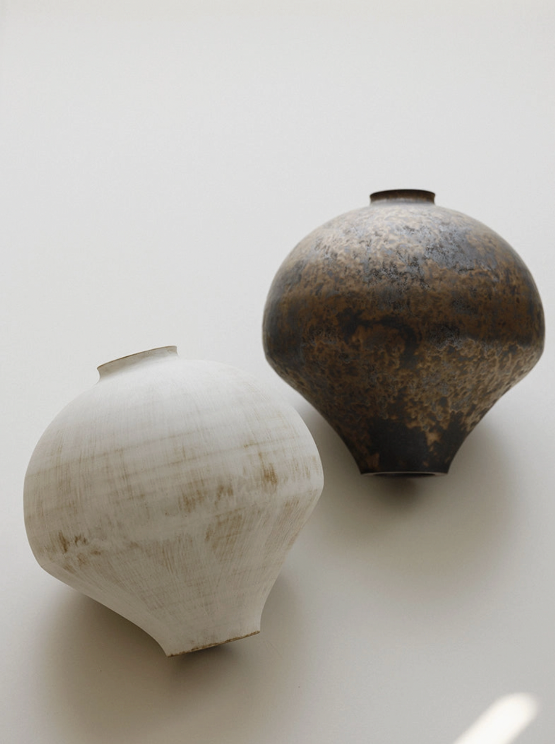 white and brown vase on white floor