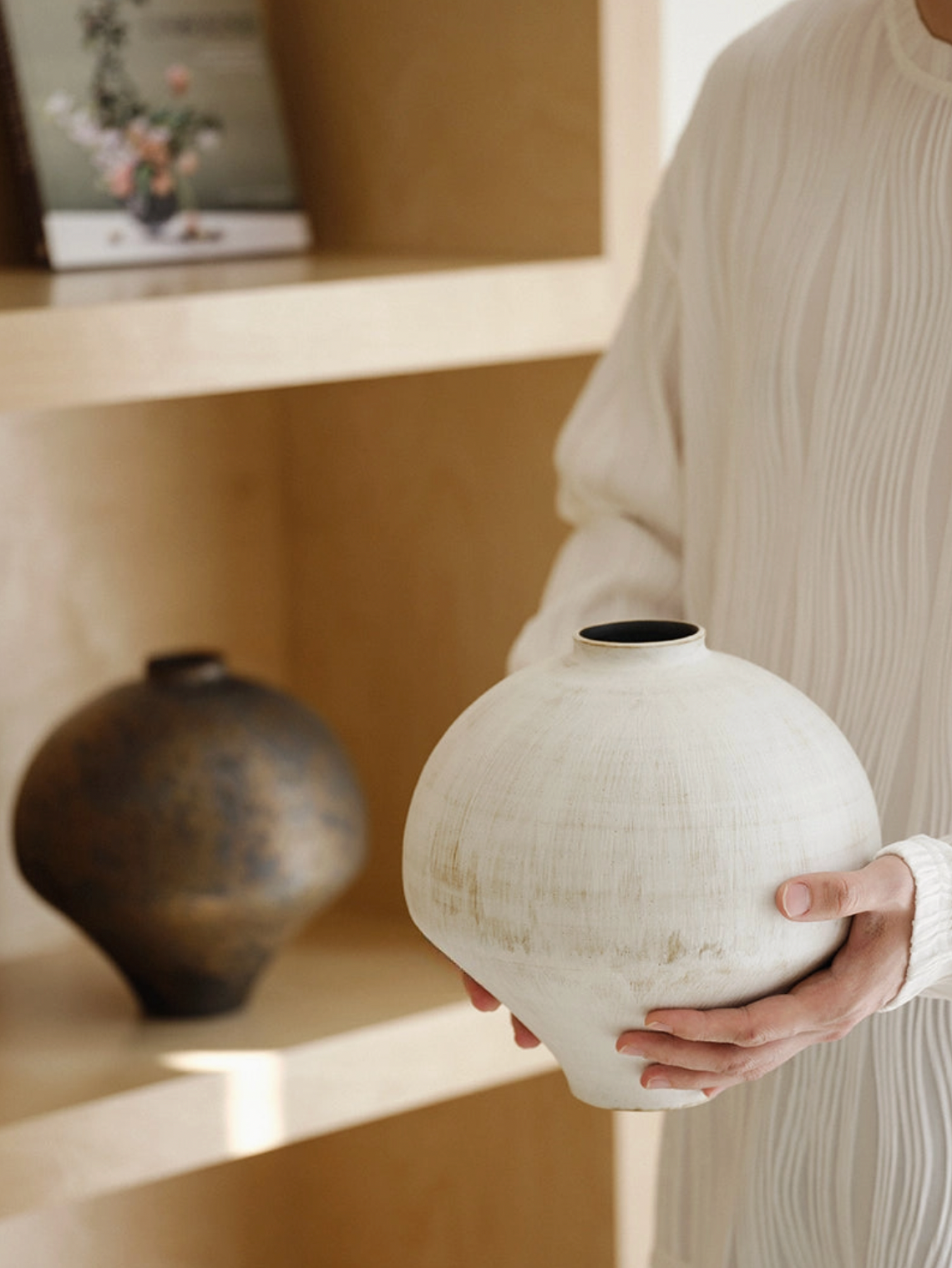 white and brown vase on white floor