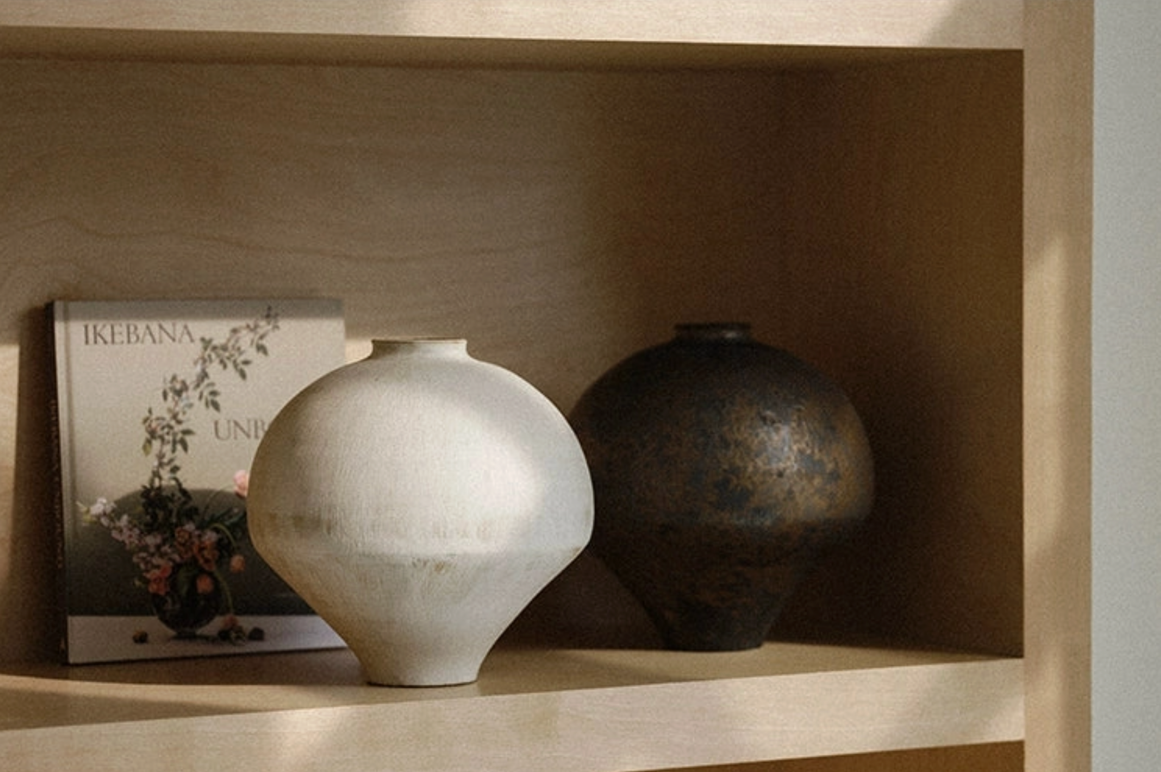white and brown vase on bookcase
