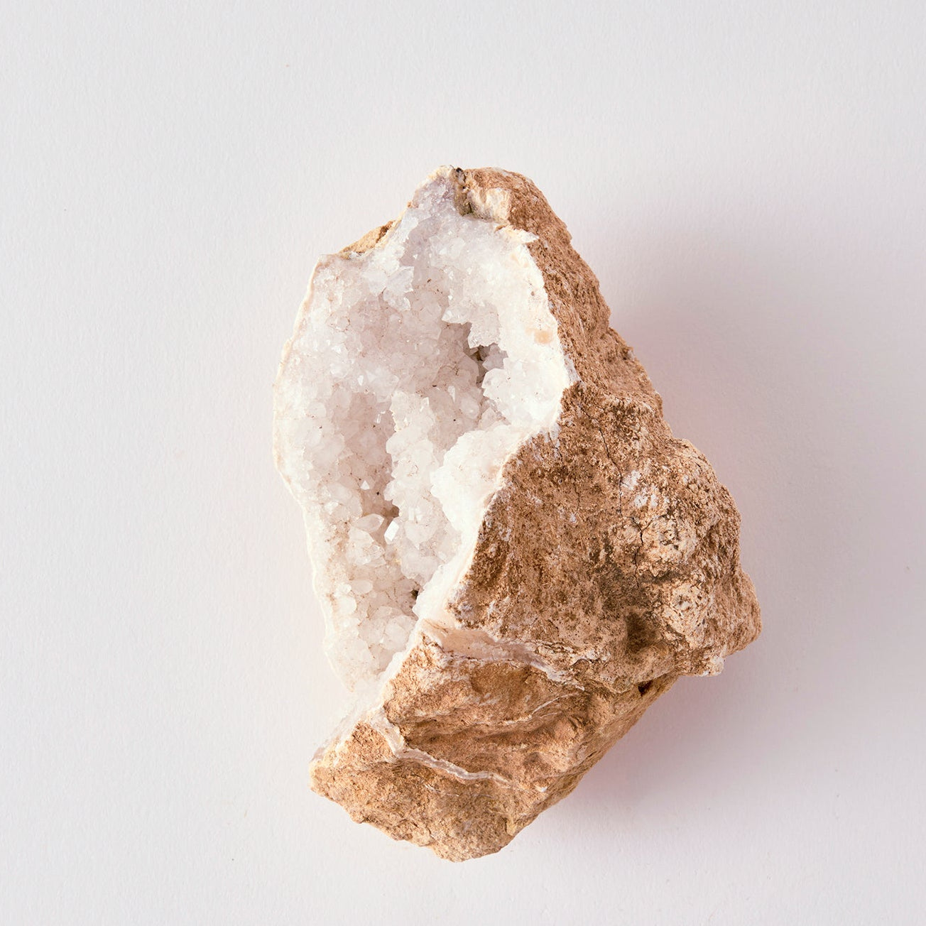 Mineral with a white interior on a light gray background