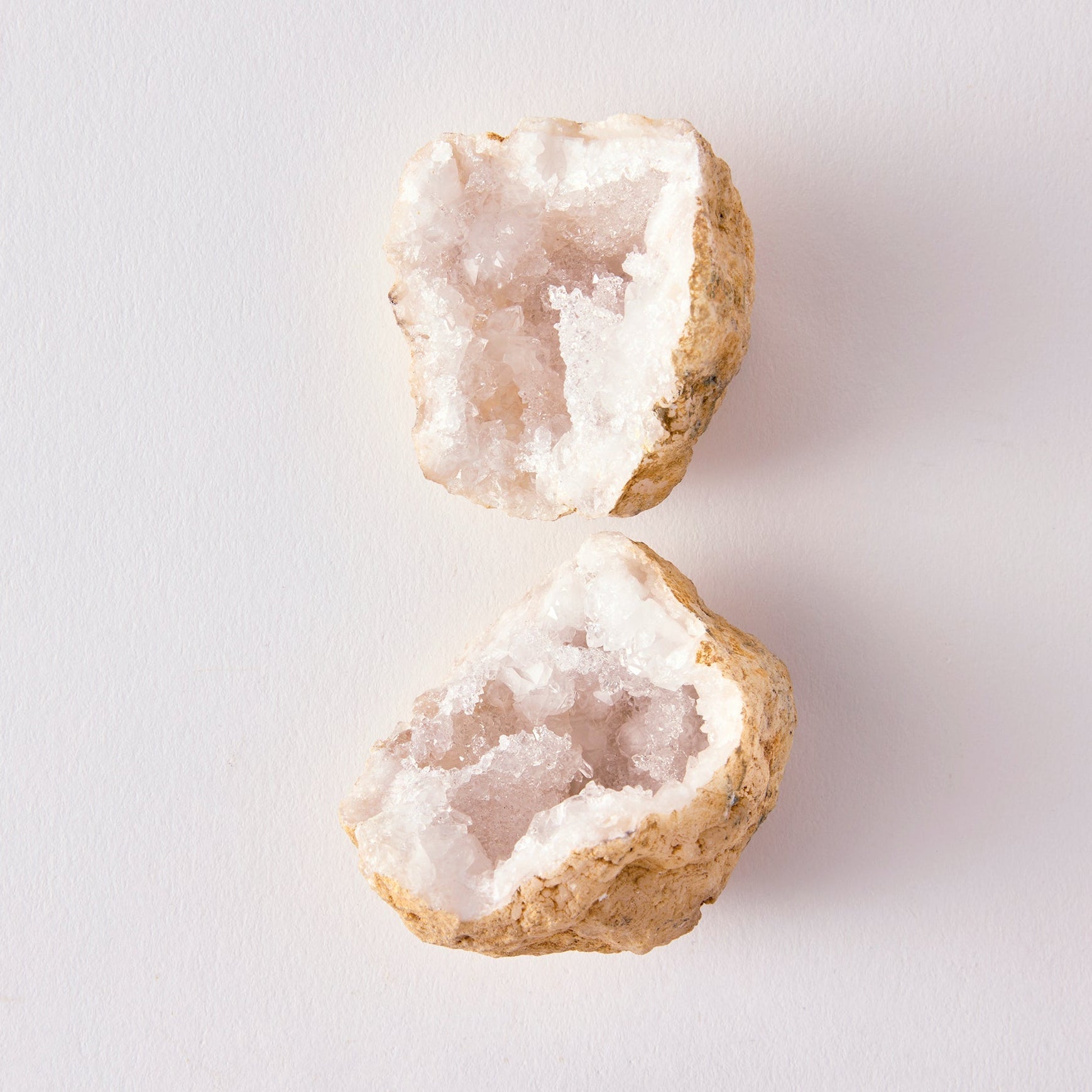 Two crystal geodes on a white background