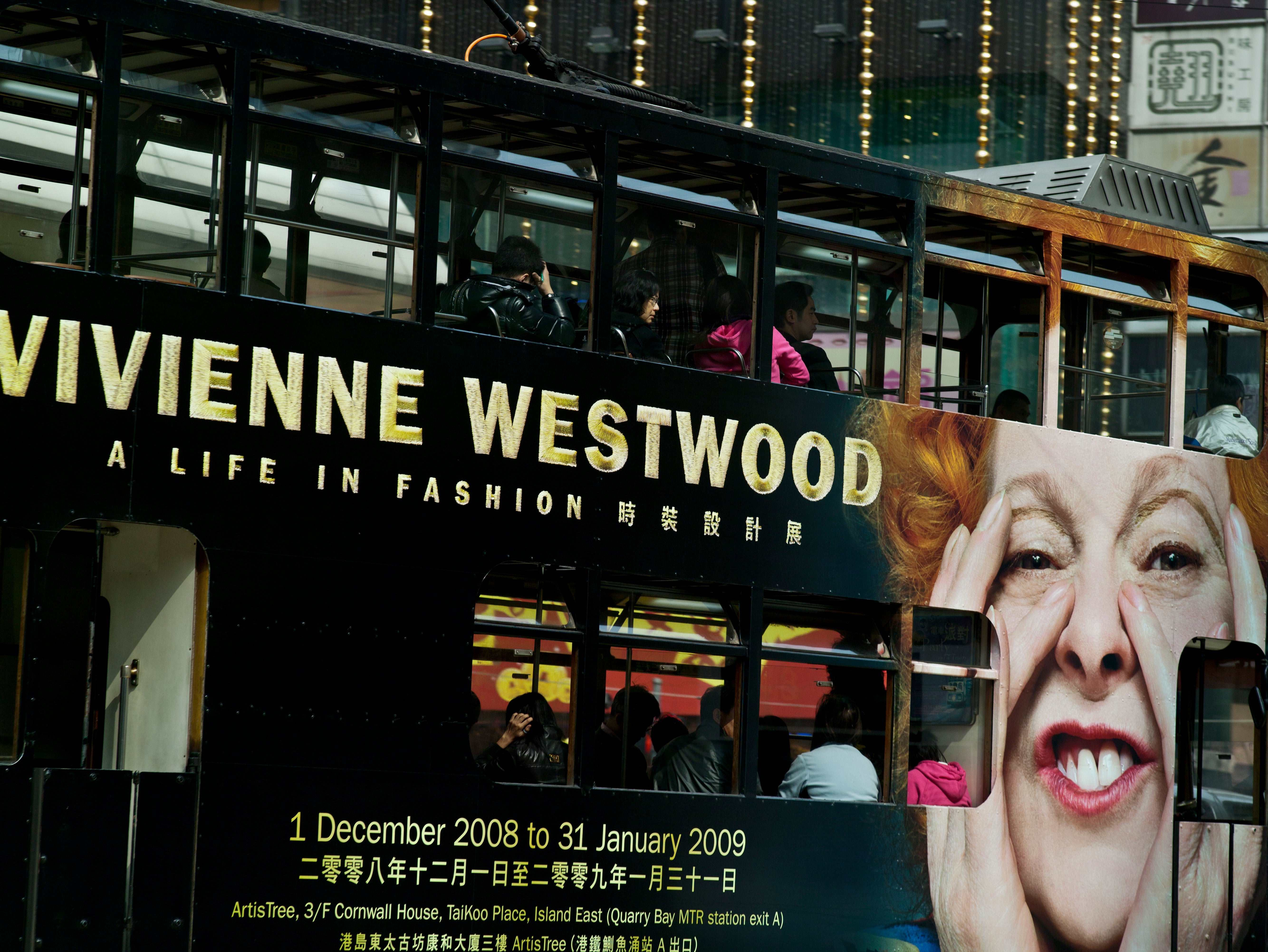 Bus with a large advertisement featuring Vivienne Westwood and a woman's face.